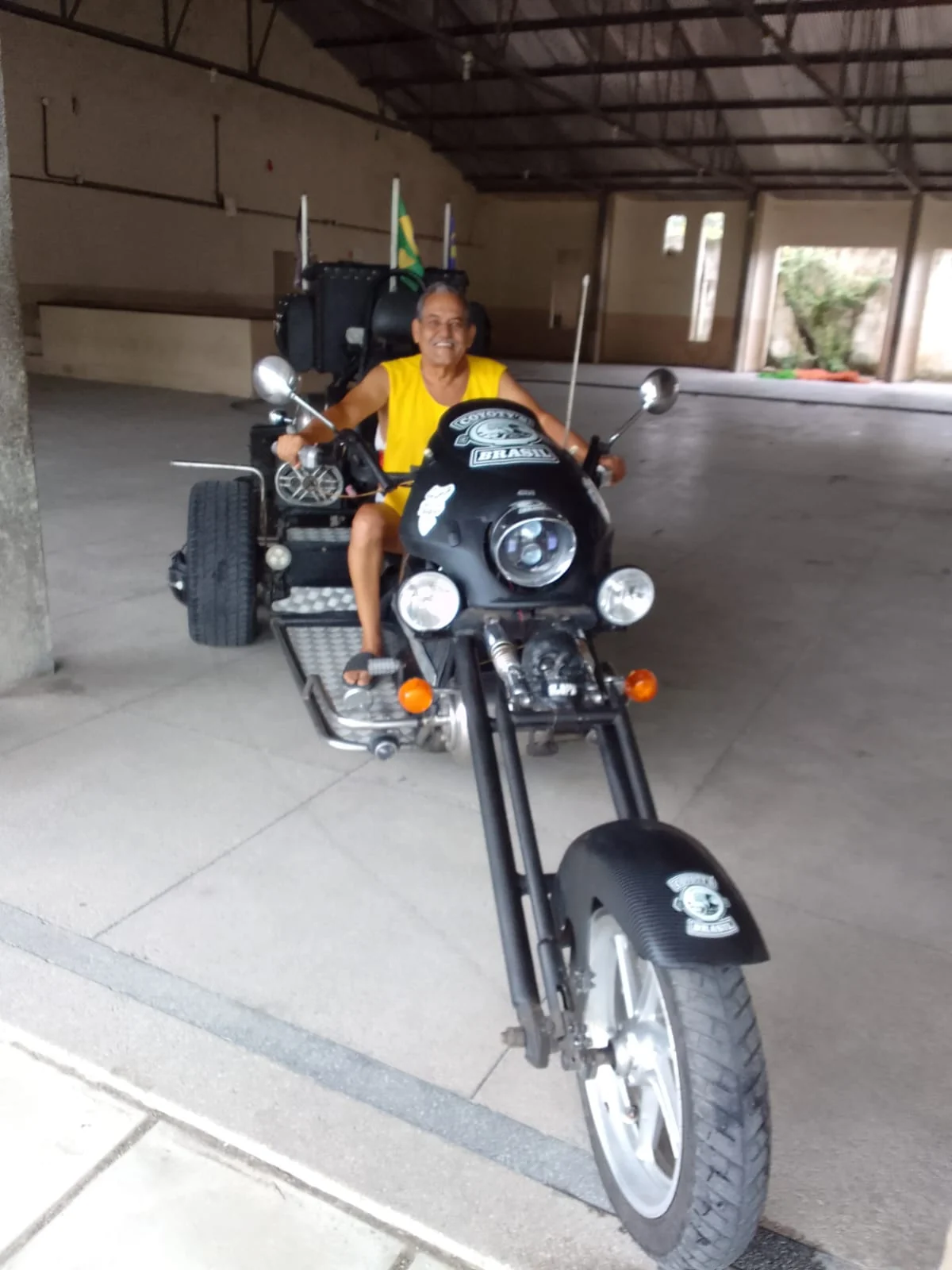 Roberto Farias em uma motocicleta em ambiente fechado